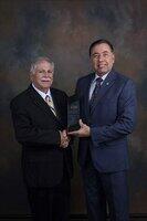 College of Extended Learning Dean Eloy Chavez, right, and Instructor Mark Tozzio pose with the ACHE Award for Outstanding Services to Underserved Populations. The award recognizes the Healthcare Administration Certificate Program which uses an online format to make U.S. certification a possibility for international health professionals.