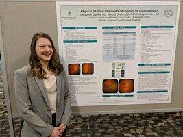 Dr. Stephanie Stanley beside presentation poster