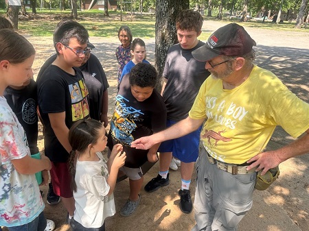 Dr. Paulissen shows a hatchling Prairie Lizard to the TCEK students (photo by Wrighter Weavel).