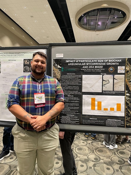 Ben Woolen with his poster titled "Impact of Particulate Size of Biochar on Arbuscular Mycorrhizae and Zea maize" at the International Botany conference.