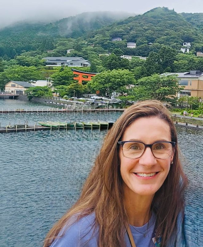 Dr. Alesha Baker enjoying the serene beauty of Lake Ashi in Hakone, with the majestic Mt. Fuji in the background.