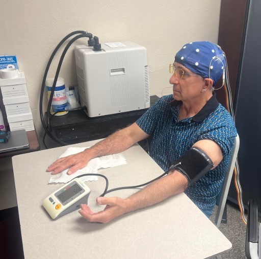 Harry Brubaker (Bill), M.Ed, MS, BCN, QEEG-D undergoing a cold pressor test while testing aroma oils administered by Dr. Beth Bowin while recording EEG.