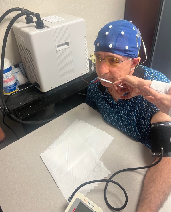 Harry Brubaker (Bill), M.Ed, MS, BCN, QEEG-D undergoing a cold pressor test while testing aroma oils administered by Dr. Beth Bowin while recording EEG.