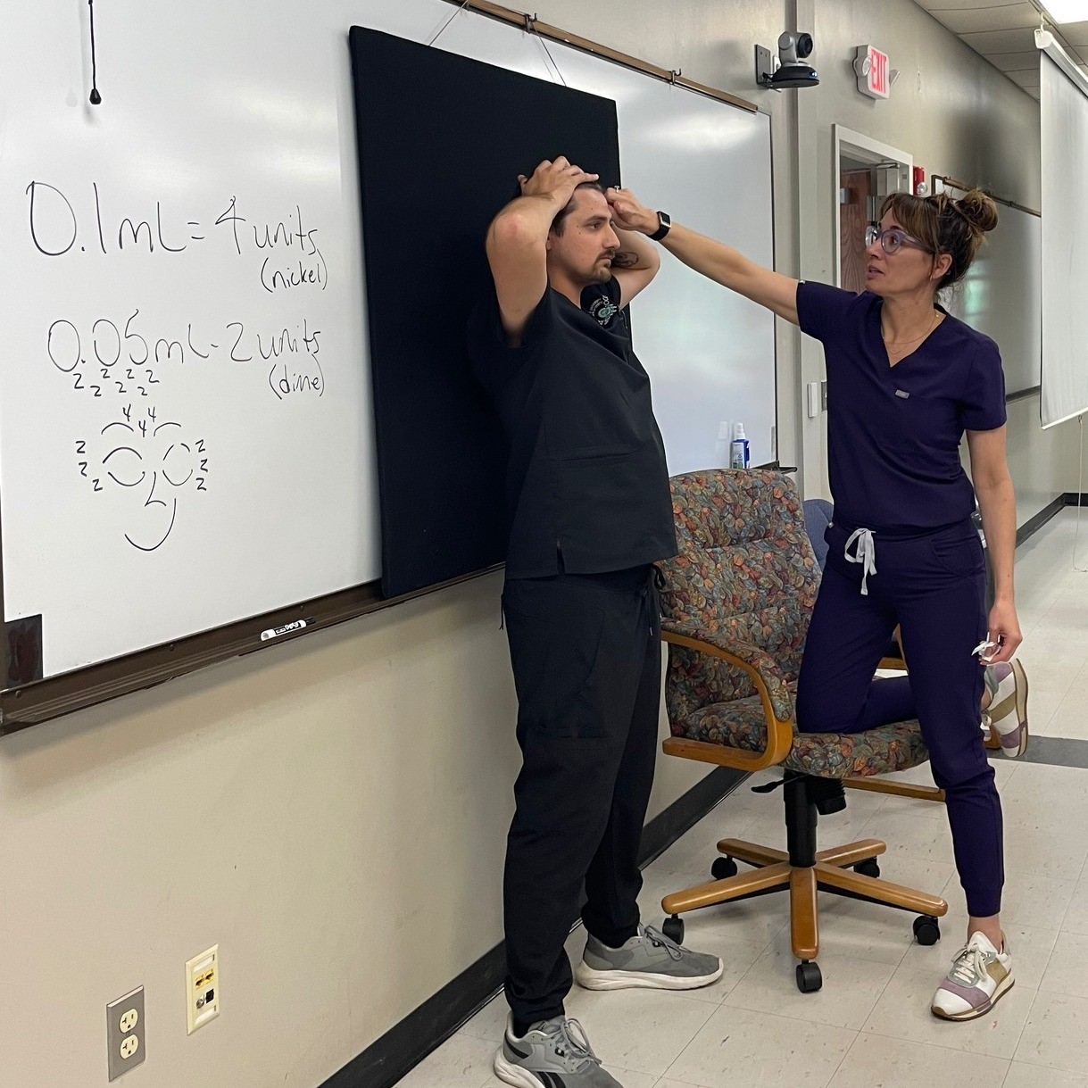 Dr. Selina McGee demonstrates placement of neurotoxin injections with 4th year student, Ryan Kerr.