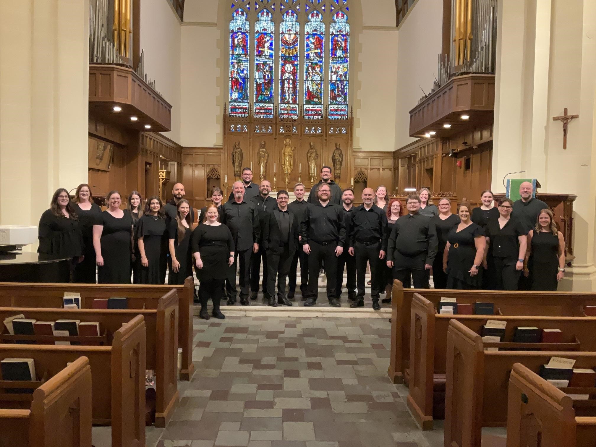 Dr. Wall and choral group on stage in Trinity Church