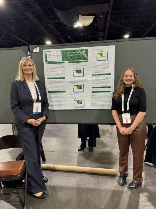 Julia Kent and Dr. Rebekah Doyle standing next to poster