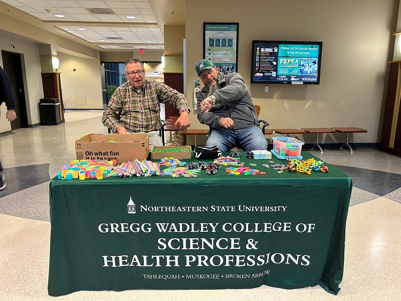 Dr. Darryl Linde and Dr. Lucas Foster passing out fidgets to students.