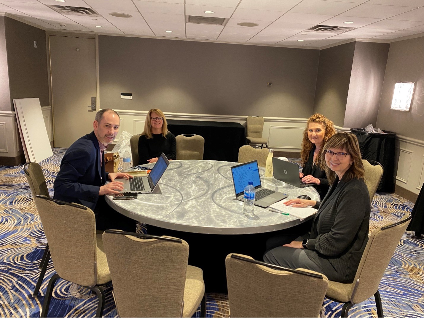 Dr. Kelli Carney at AACTE conference around table with three other attendees