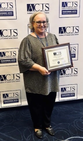 Dr. Jennifer Edwards holding award