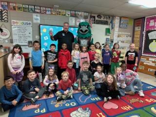 NSU mascot, Rowdy, with retired Chief of Police visitng class in Broken Arrow as part of the Read Across America Program.  