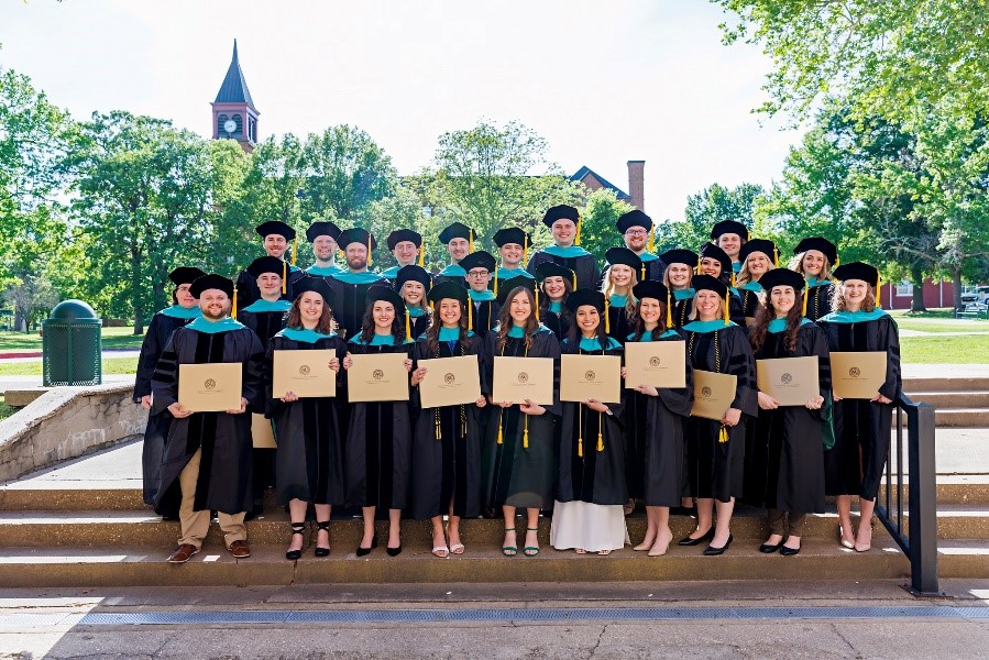 NSUOCO graduating students holding diplomas