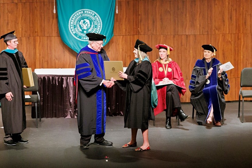 NSUOCO student receiving diploma from Dr. Penisten