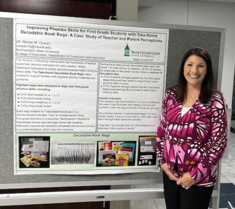 Dr. Cowan is pictured with her research poster display. Dr. Cowan is pictured with her research poster display.