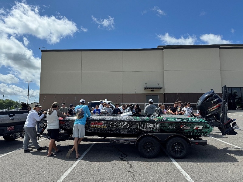 Group of students surrounding the NSU fishing bass boat
