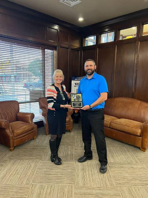 Vanessa Anton, COE Dean, presents Josh Stafford, BancFirst, with their first-place tournament plaque.