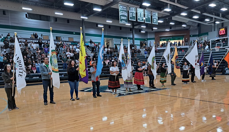 Students and staff presenting Tribal flags at Nike N7 Indigenous Peoples' Night basketball game