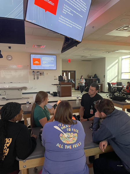 Optometry students, Chelsea Leonard and Alex Foree, teaching OSU-COM students to use a panoptic to look in the back of the eye