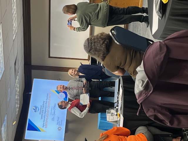 Dr. Spence Pilcher receiving his award and certificate for completing the program.