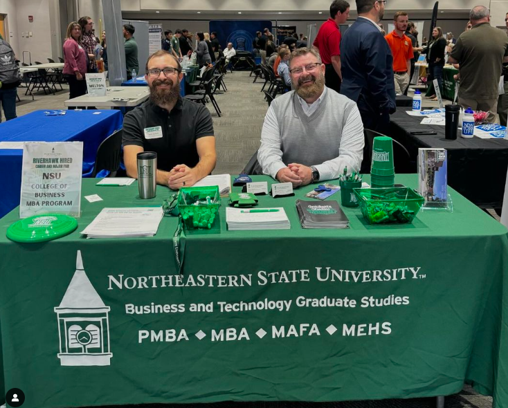 Dr. Seth Smart, and GA Ryan Fitzpatrick seated by informational table