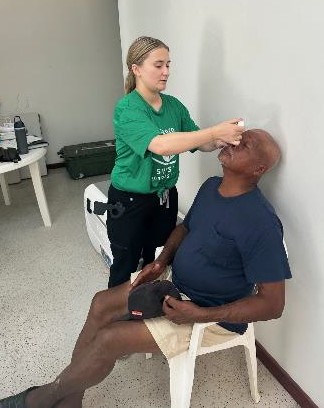 Lindsay Anstine putting dilation drops in a patient's eyes. 