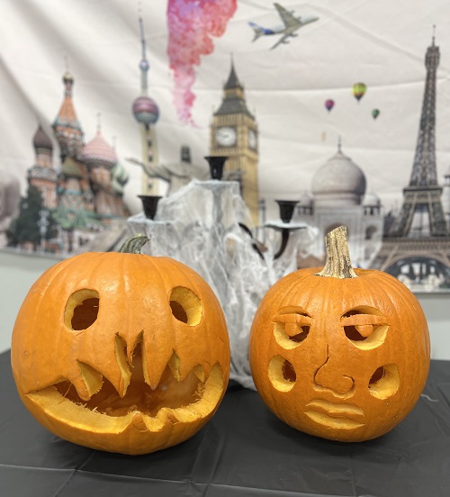 Two pumpkins carved by current international students displayed on table in the Office of International Programs.