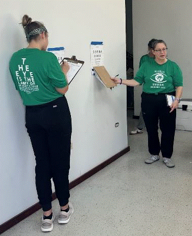 Paige Chanay (L),  Rebecca McNeill (R) doing distance acuities. 