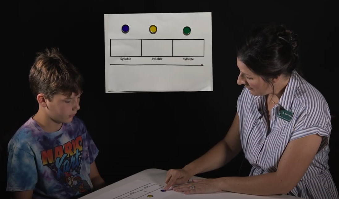 Dr. Renée Cowan teaches a student how to use a Syllable Mat