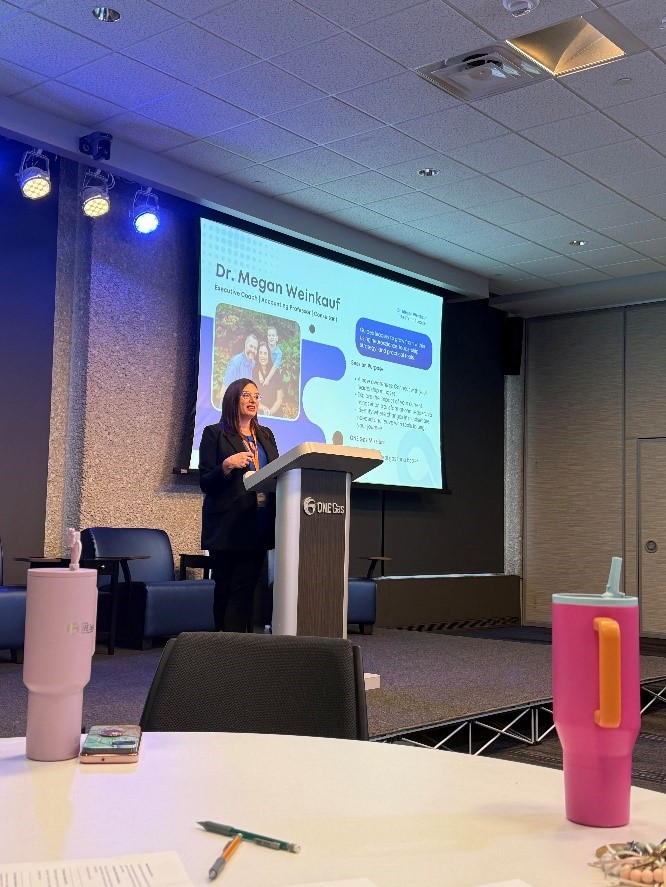 Dr. Weinkauf behind podium presenting at conference