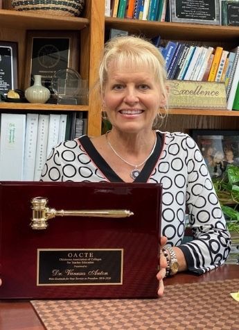 Dr. Vanessa Anton holding OACTE Oklahoma Association of College for Teacher Education plaque.