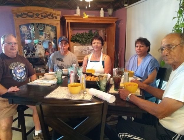 Dr. Kracht, Carlos and Lisa LaBrada, Raymond Tongkeamha seated around dining table.