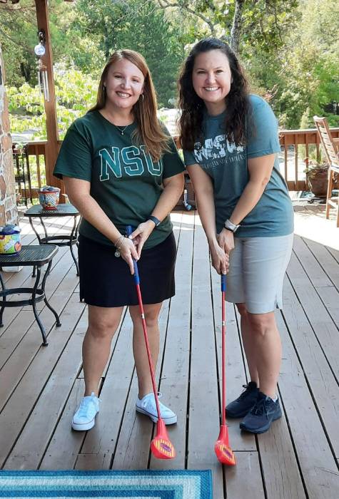 Dr. Brandy McCombs and Dr. Christine Gleason with golf clubs