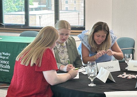 Noyce Scholars JaiCee Lester, Avi Delap, and Allison Henry examine data from the tennis ball task. 