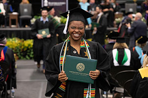 student holding diploma at graduation_